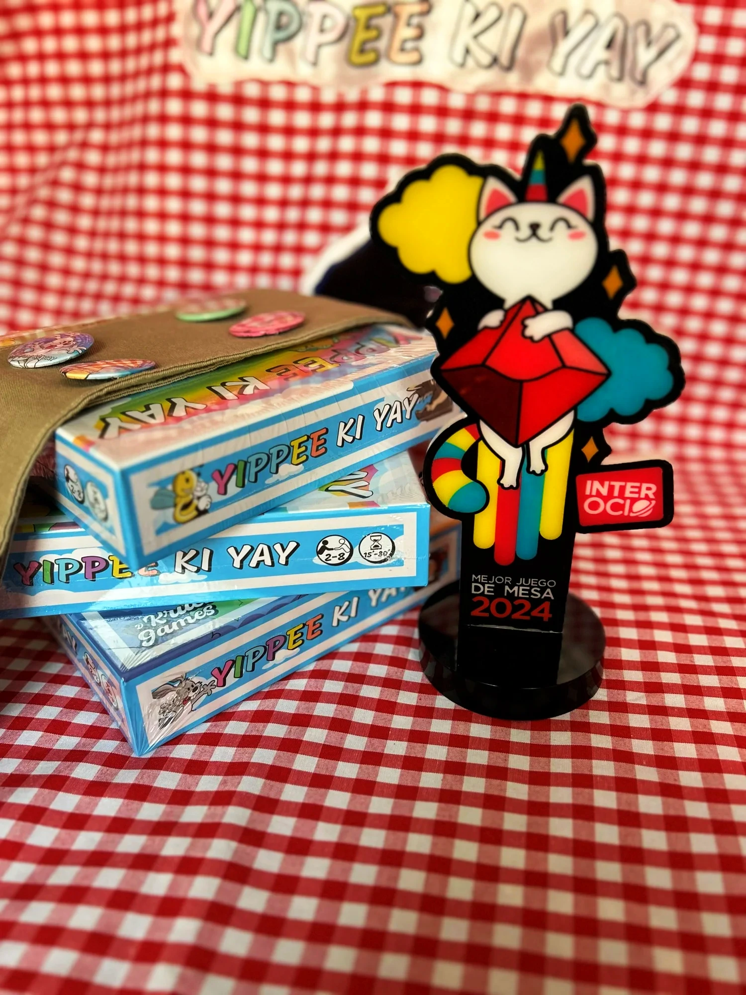 Cajas de Yippee Ki Yay junto al trofeo de Mejor Juego de Mesa Interocio 2024
