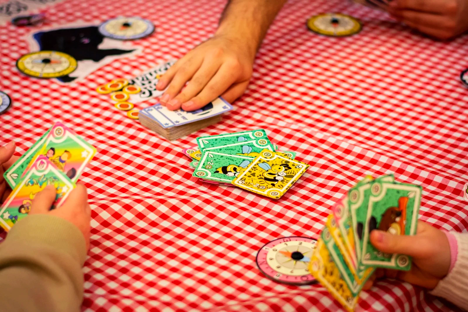 Partida de Yippee Ki Yay con cartas y brújulas sobre un mantel de cuadros